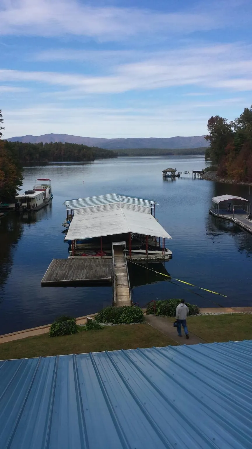 View across a lake from a newly installed blue metal roof in Winston